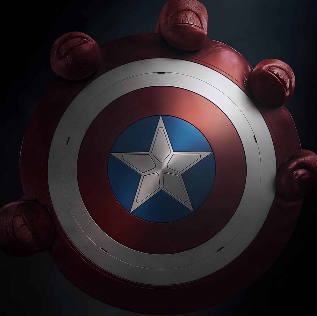 Captain America: Brave New World promotional image with Captain America's shield being held by large dark red hands