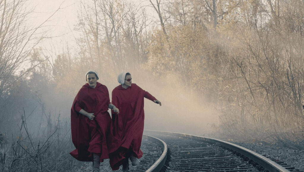 Handmaids in red cloaks in a scene from The Handmaid's Tale, a dystopian Hulu show.