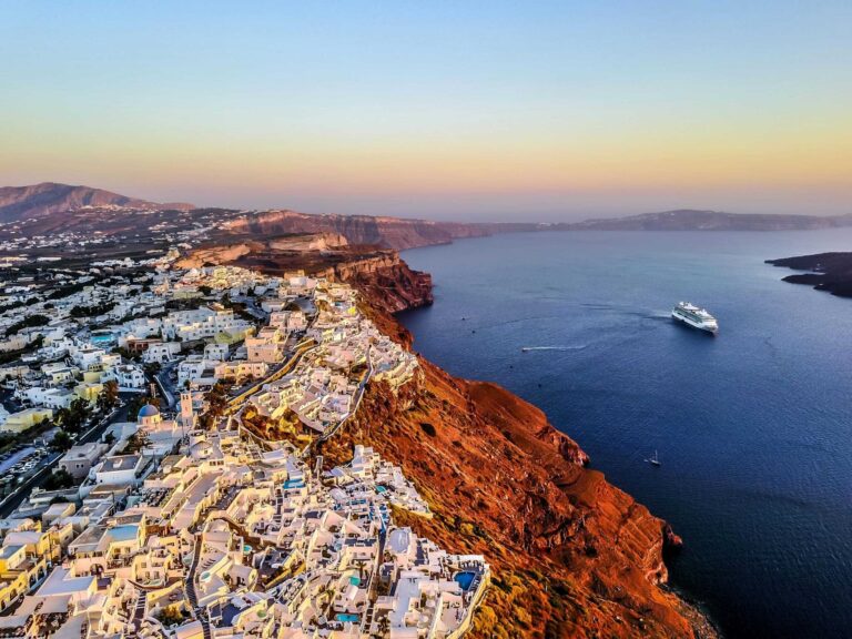 Stunning aerial shot of Santorini coast at sunset with a cruise ship in the Aegean Sea. Spiritual Getaway location