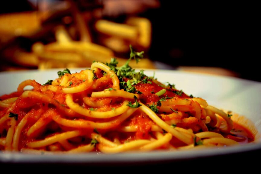 A plate of spaghetti with tomato sauce and parsley, global cuisine