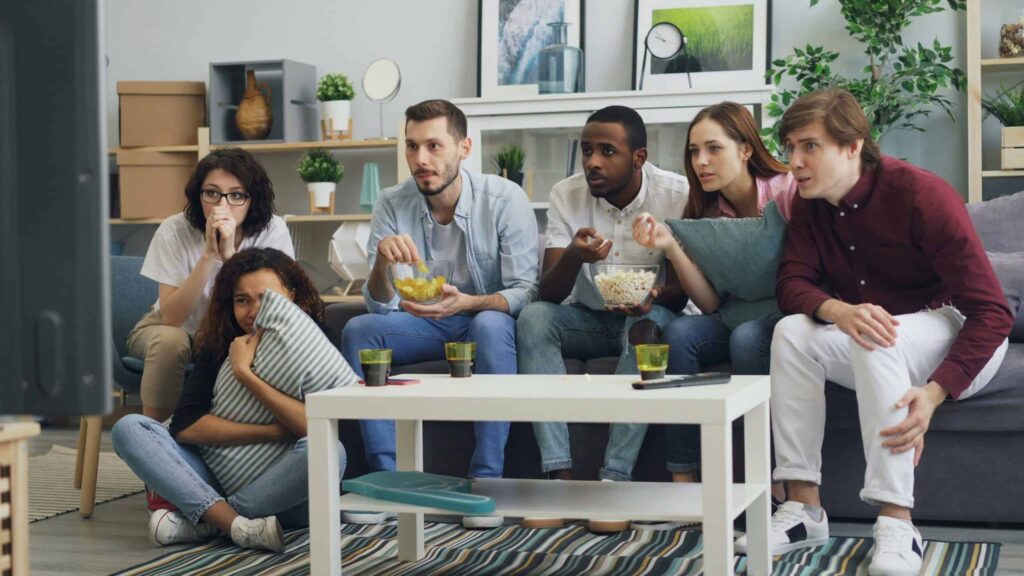 a group of people sitting on a couch in a living room / TV ratings