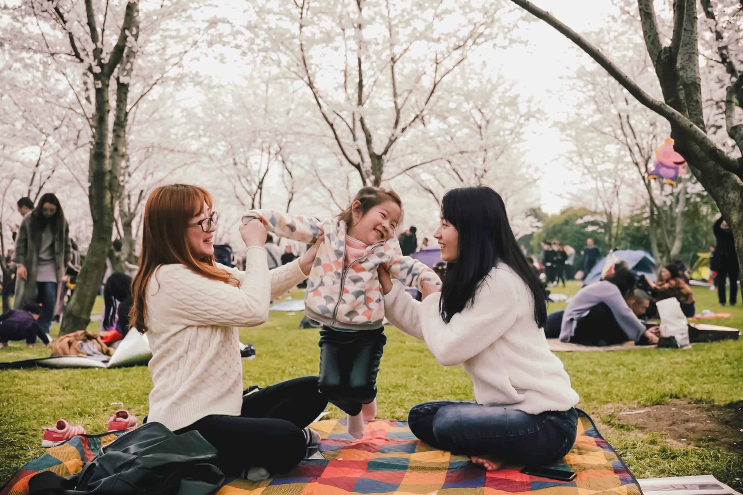 Photo of two women and a child having a picnic