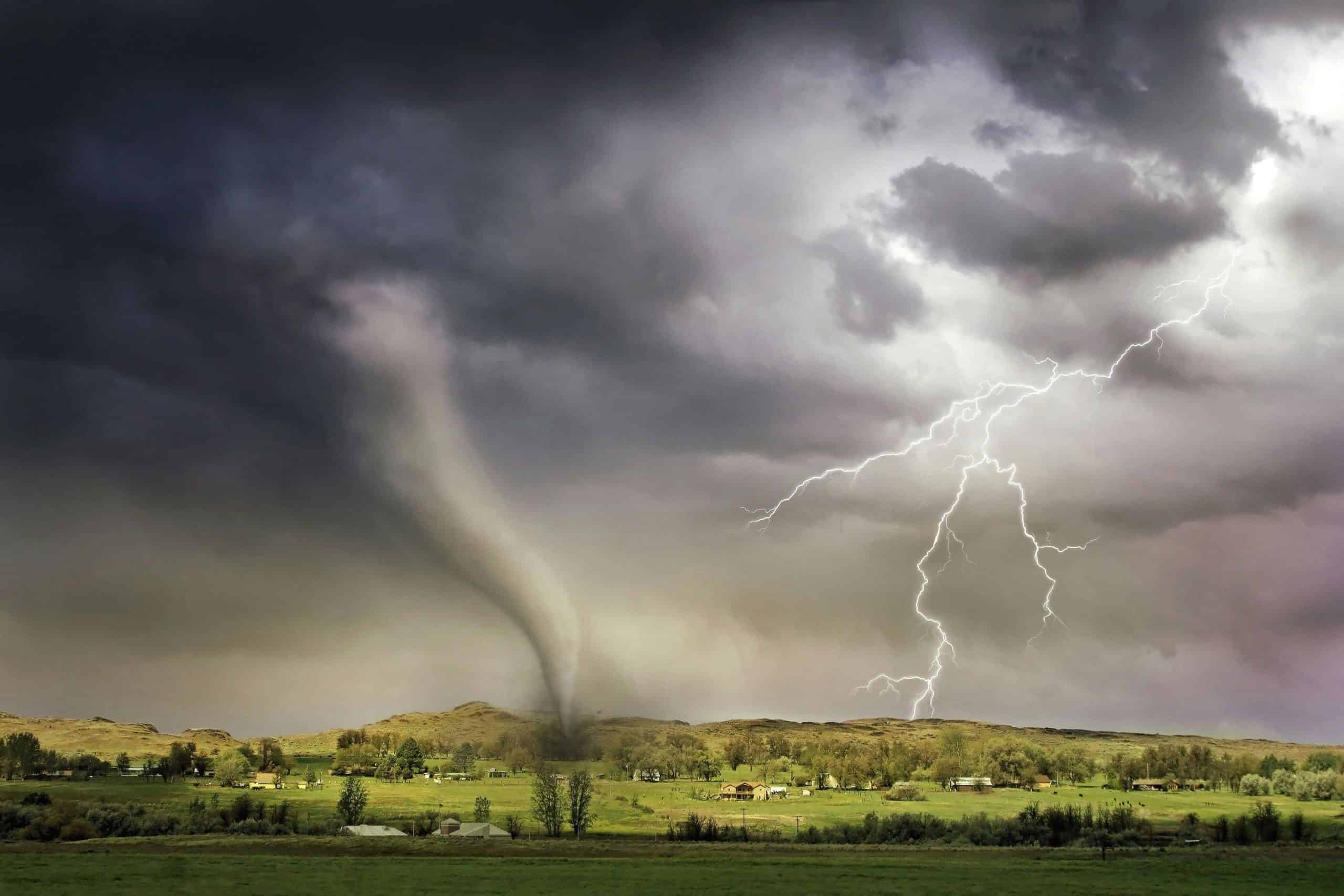 A powerful tornado and vibrant lightning striking over a rural countryside landscape., family