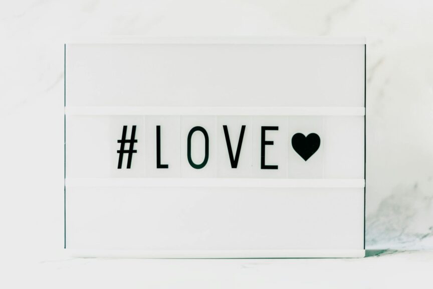 Contemporary minimalist sign displaying '#LOVE' in text with a black heart on a white background. venus in leo, love, bold love, emotional shifts,