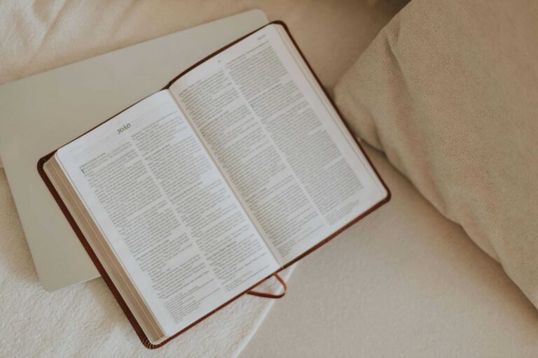 Daily Devotion. An open Bible on a beige blanket, inviting peaceful reflection and spiritual reading.