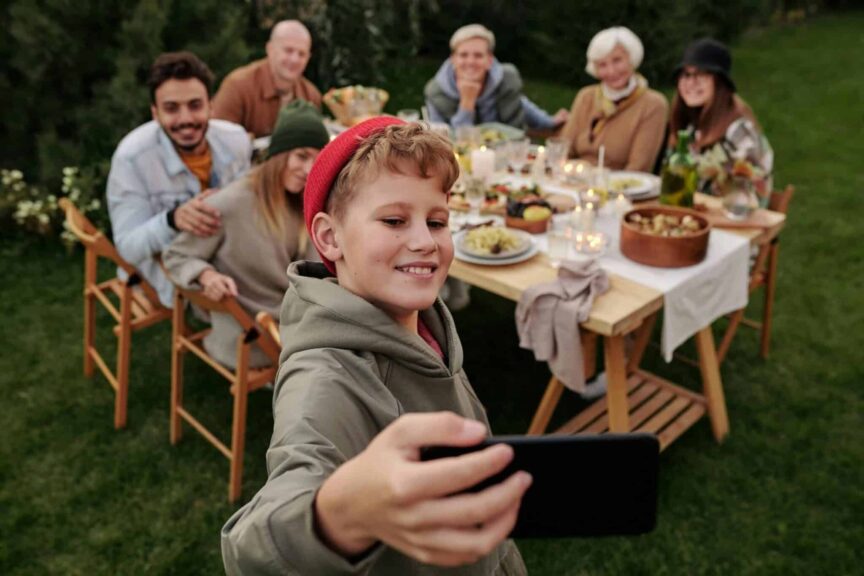 generational differences, families, Cheerful family taking a selfie during an outdoor garden dinner party.