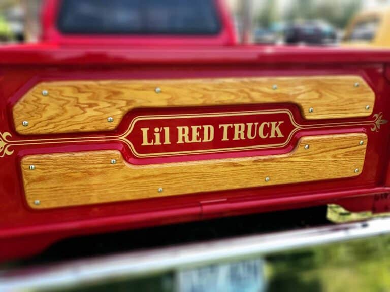 tailgate,Close-up of a vintage Li'l Red Truck showcasing retro design and wooden panels.
