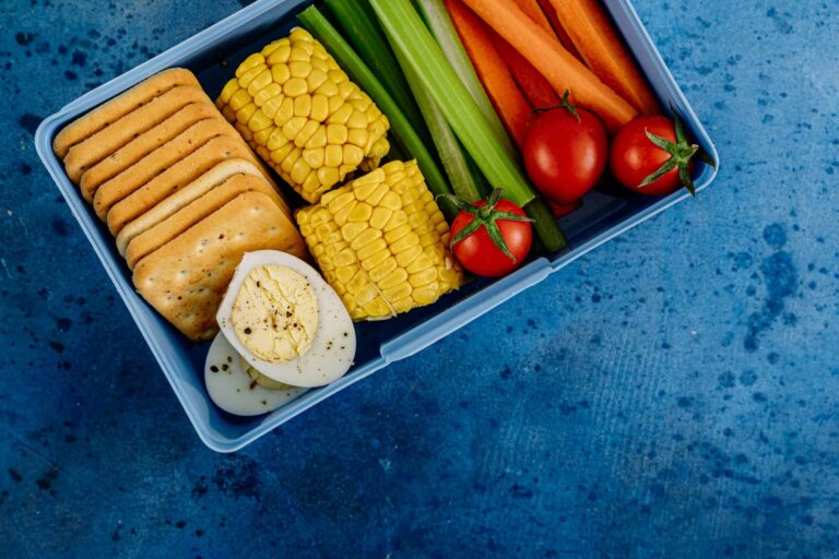 A vibrant lunchbox filled with nutritious vegetables, eggs, and crackers for a healthy meal. Lunchbox wellness