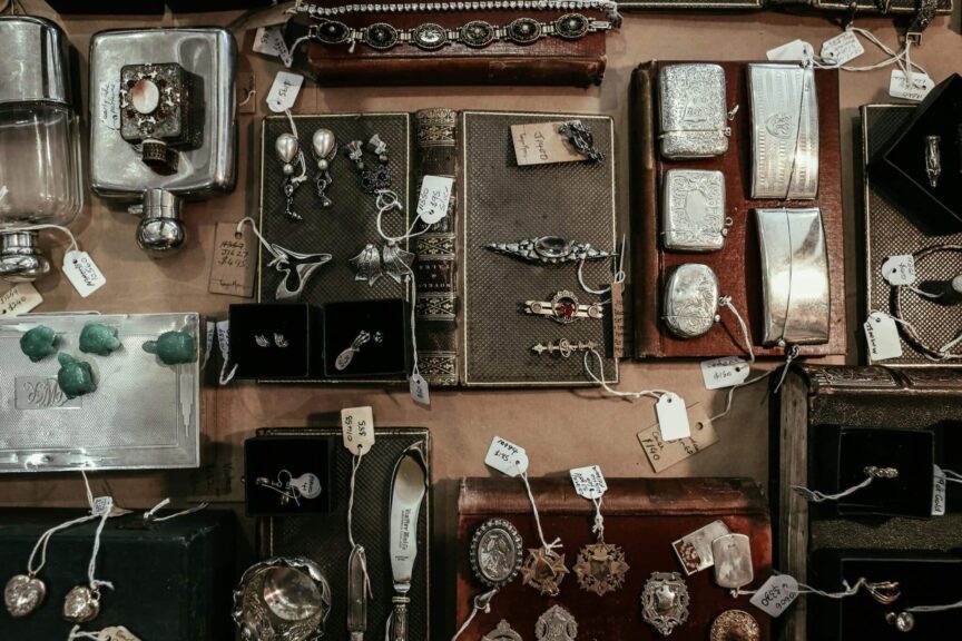A curated selection of vintage and antique items on a display, including jewelry, books, and decorative pieces. antique shops