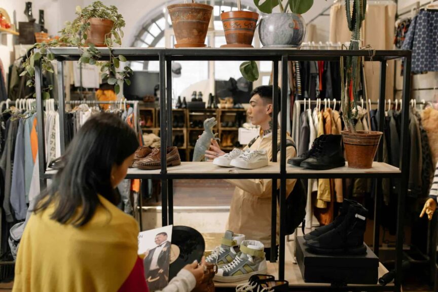 People browsing and selecting items in a stylish vintage clothing shop interior. second-hand shopping