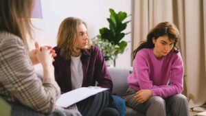 A psychotherapist talks with clients during a session, the kind of setting where experts say AI in therapy should come up