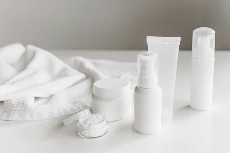 This photograph features a towel and a set of skincare products. Minimalist skincare involves using a few products that benefit skin.