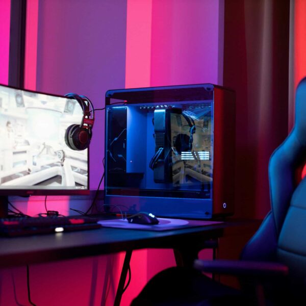 A sleek gaming setup featuring a high-end PC, widescreen monitor, and ergonomic chair lit by neon lights. off grid