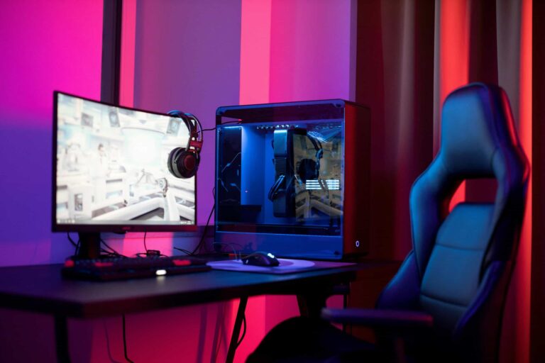 A sleek gaming setup featuring a high-end PC, widescreen monitor, and ergonomic chair lit by neon lights. off grid