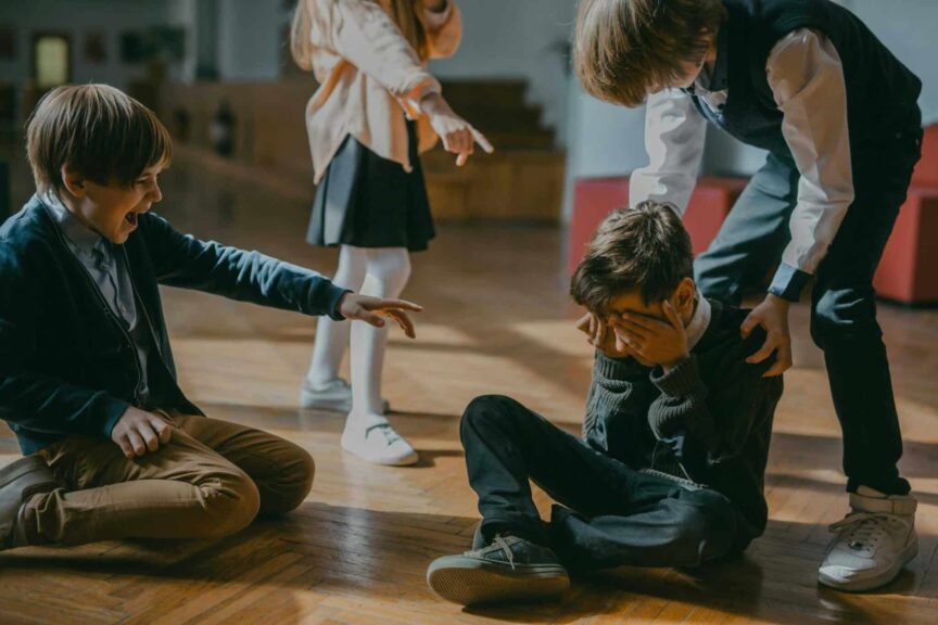 Group of kids bullying another child at school, signaling peer pressure and harassment. upstander
