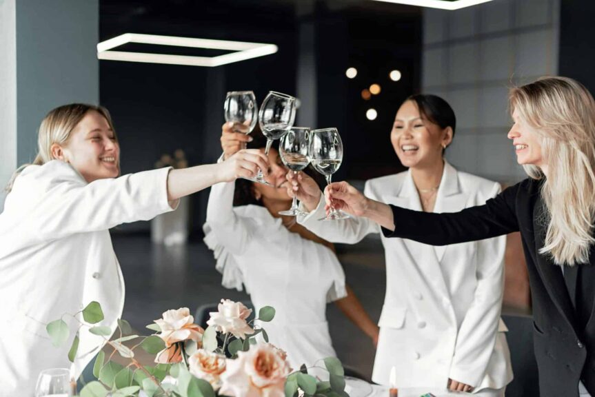 Two women celebrating long-distance friendships indoors, clinking wine glasses with joyful smiles during a toast. Photo by Mikhail Nilov via Pexels.