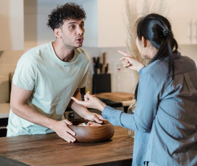 A couple engages in a heated discussion in a contemporary kitchen, highlighting relationship dynamics.