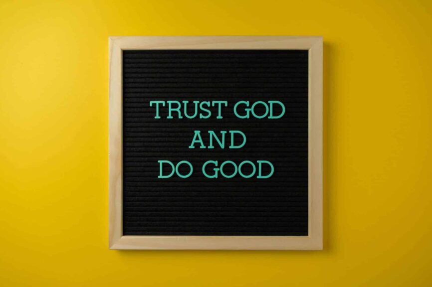 Inspirational message 'Trust God and Do Good' on a stylish black letter board with a vibrant yellow background. Proverbs 3