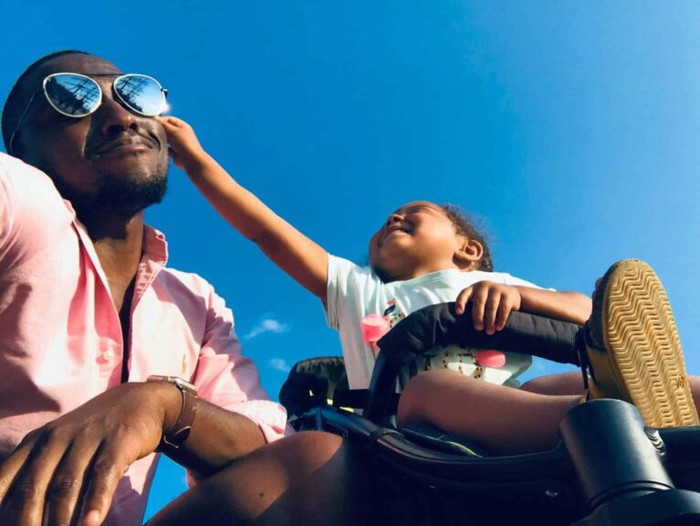 Happy father and daughter bonding moment outdoors under a clear blue sky. Gentle parenting