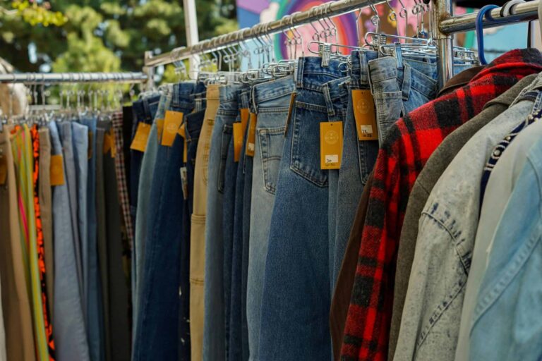 A rack of vintage jeans and shirts at an outdoor flea market in Los Angeles, CA. / anti-American sentiment