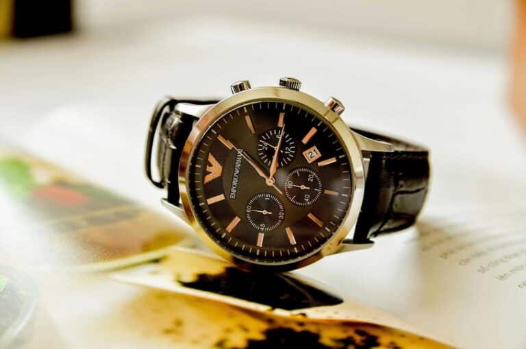 Armani, style lessons, Close-up of a stylish Emporio Armani watch resting on an open book, showcasing luxury and elegance.