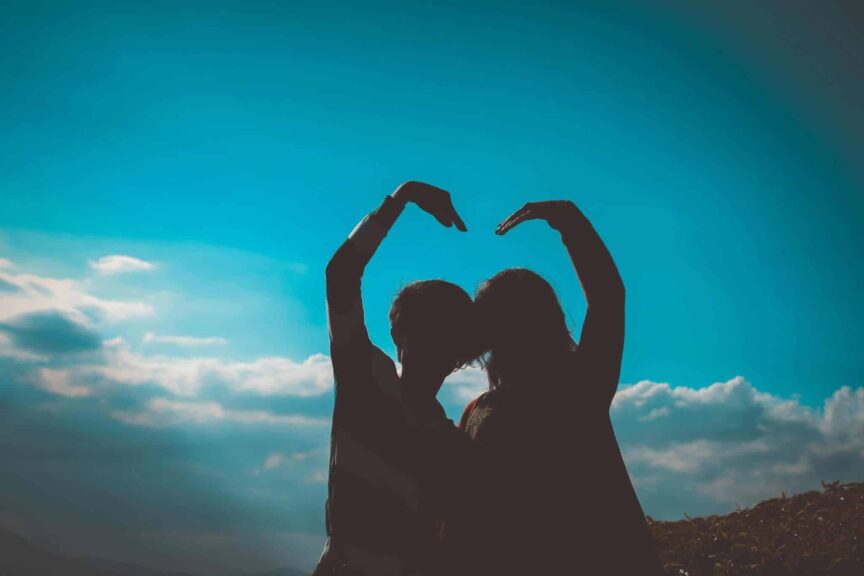 Emotional Intelligence, Silhouette of a couple creating a heart shape with their arms in a romantic outdoor setting.