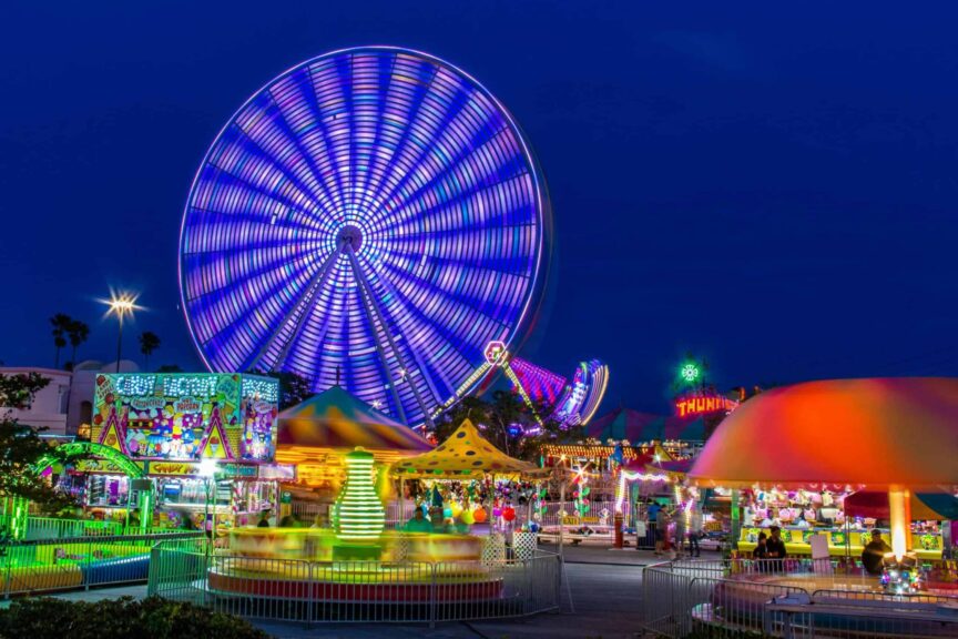 Autumn, love life, Brightly lit amusement park with a spinning Ferris wheel at night.