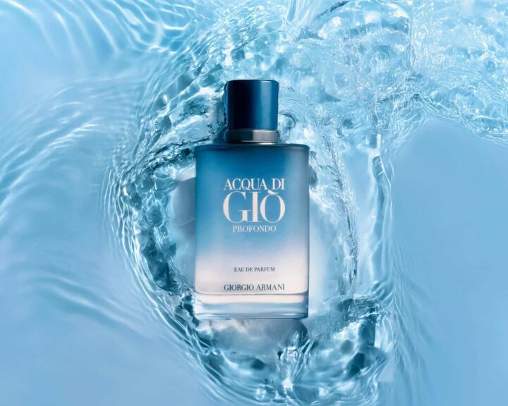 A stylish perfume bottle submerged in calming blue water, evoking freshness and elegance. Armani