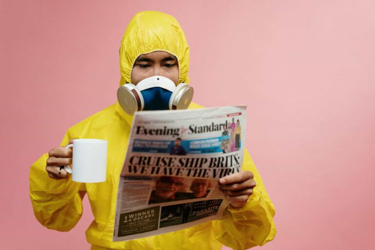 CDC, food poisoning, Person in yellow protective suit reading a newspaper with a mug.