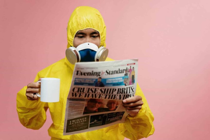 CDC, food poisoning, Person in yellow protective suit reading a newspaper with a mug.