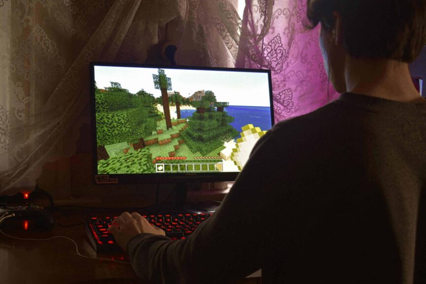A young man intensely playing a PC video game indoors. Capturing the essence of technology and concentration. Generation Alpha