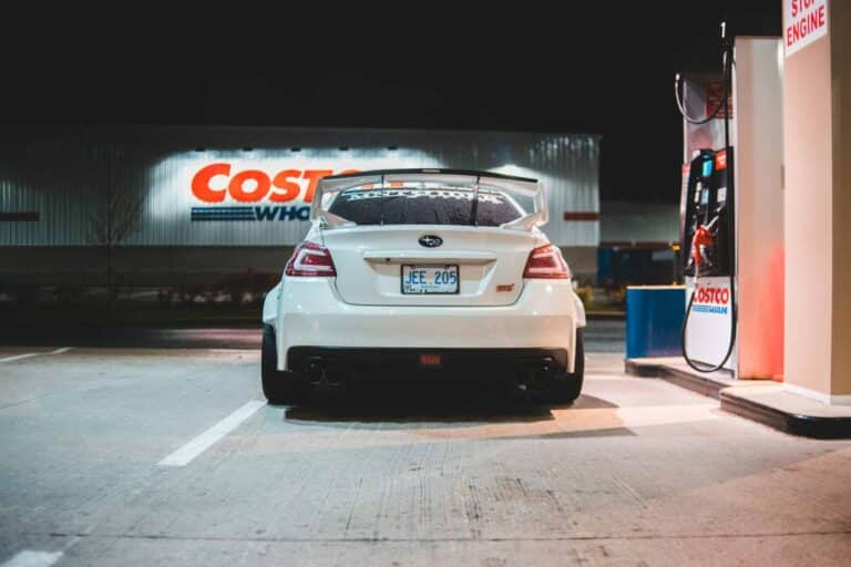 Costco, Contemporary white car parked near pump on fuel station at night in city