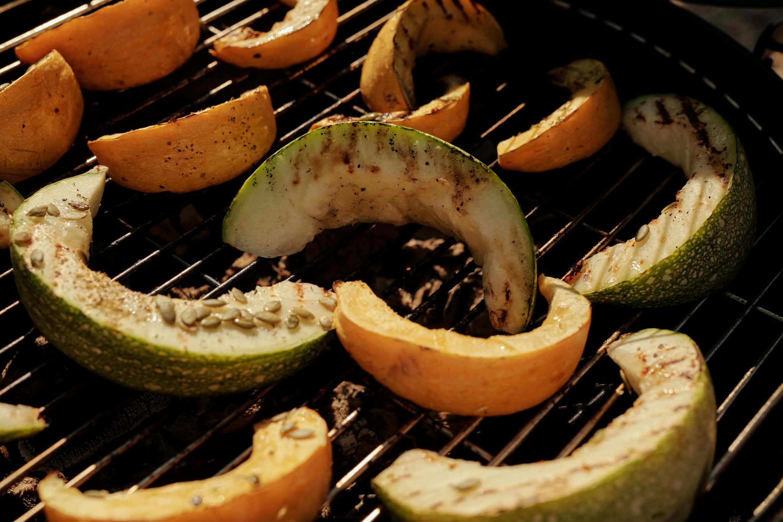 Close-up of sliced cantaloupe and melon on a barbecue grill, perfect for summer cooking.