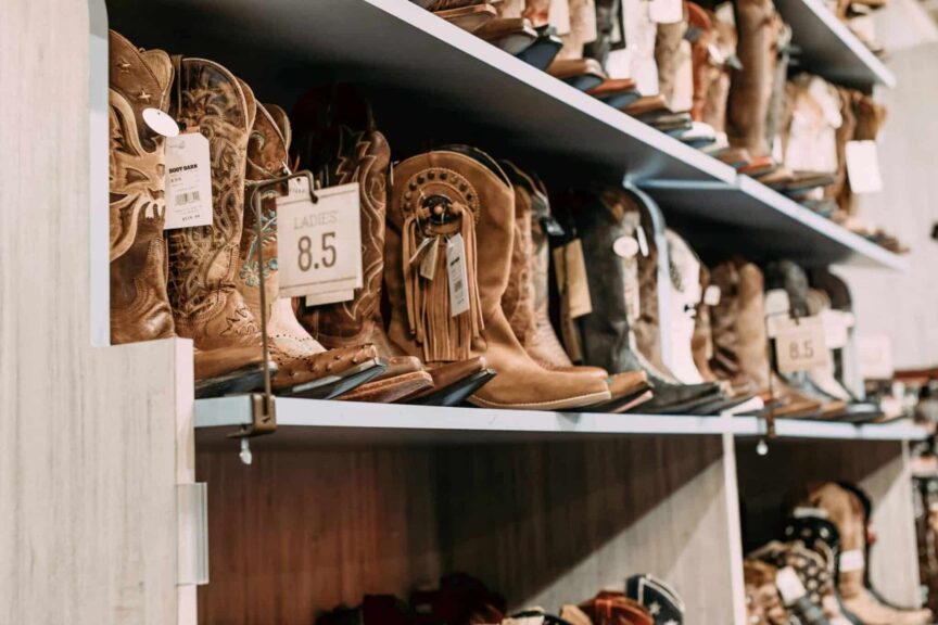 fall boots, Variety of cowboy boots displayed on shelves in a fashionable footwear store.