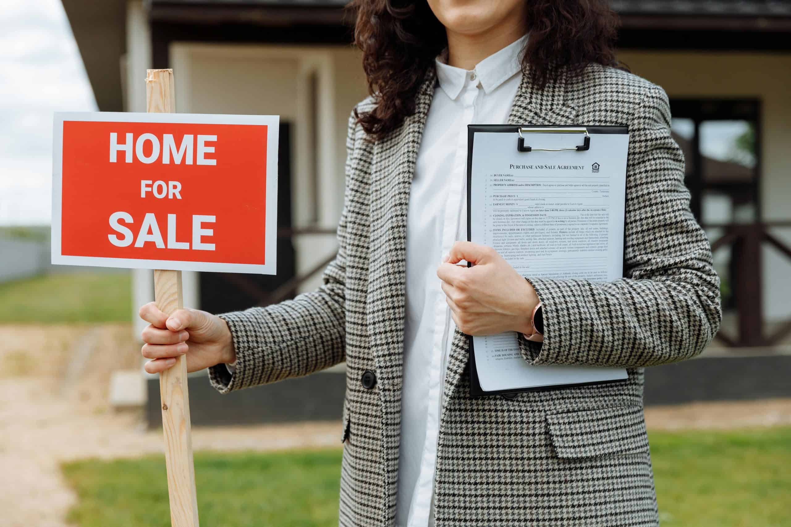 A real estate agent holding a home for sale sign and clipboard outside a property. Related to Conjuring House article