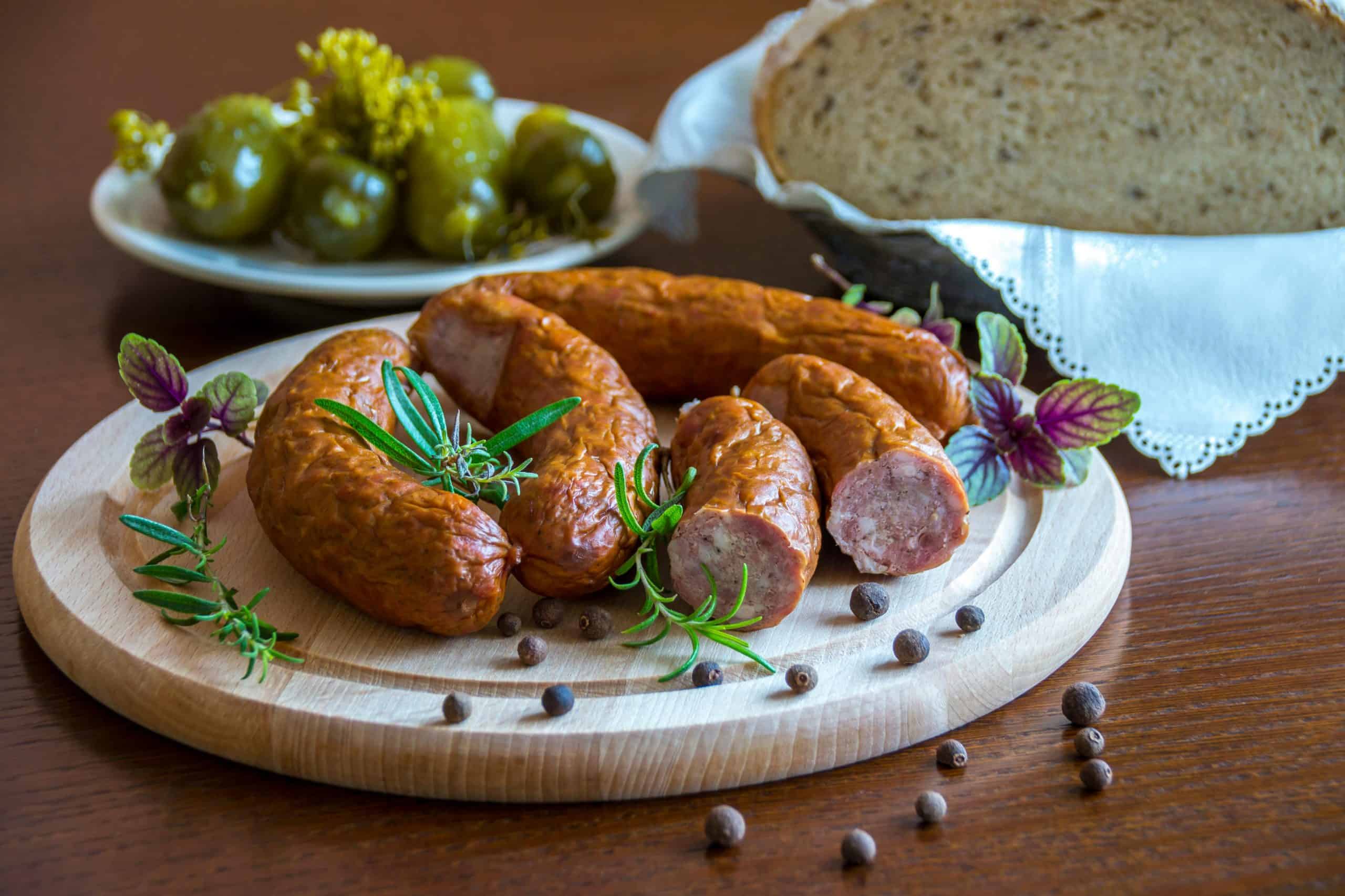Tantalizing platter of sausages with herbs, bread, and pickles.