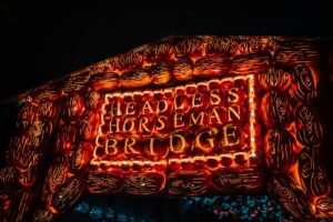 a lit up sign that says, headless horseman bridge Sleepy Hollow New York