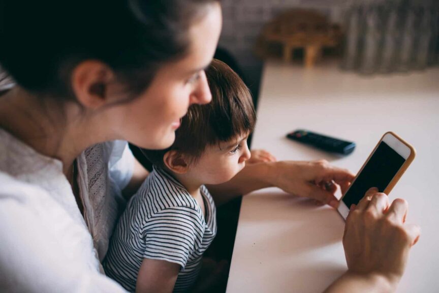 A mother and child bonding while using a smartphone at home. Parenting support from the bobo app.