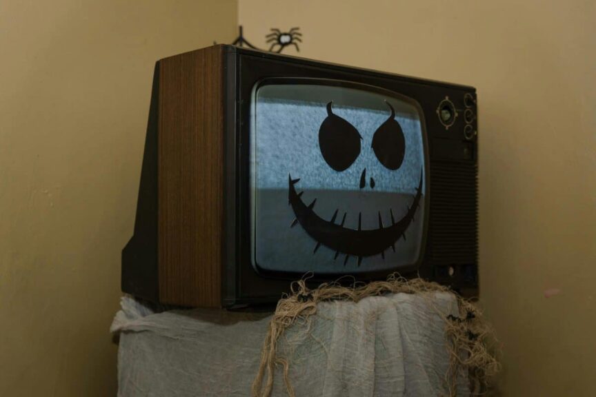 Retro TV adorned with a spooky Halloween face, creating a nostalgic eerie vibe.