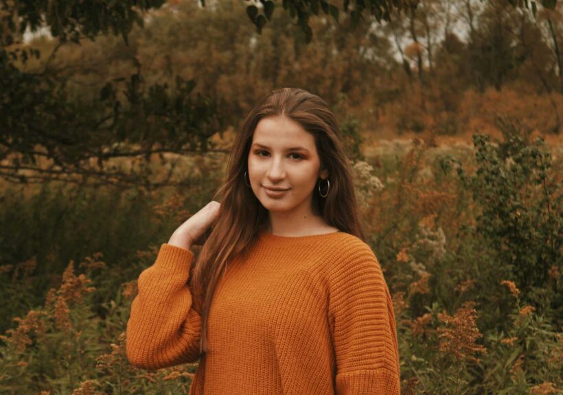 This is a photograph of a woman outside during fall. There are fun new beauty products to try out this season.