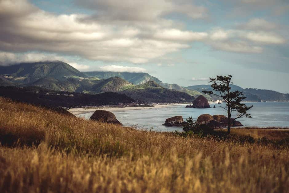 Beautiful view of Cannon Beach, Oregon, featuring Haystack Rock with coastal mountains in the background.