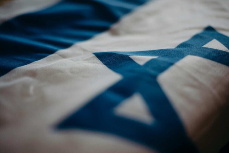 Detail of the Israeli national flag highlighting the Star of David, emphasizing its cultural significance., Warner Bros Discovery