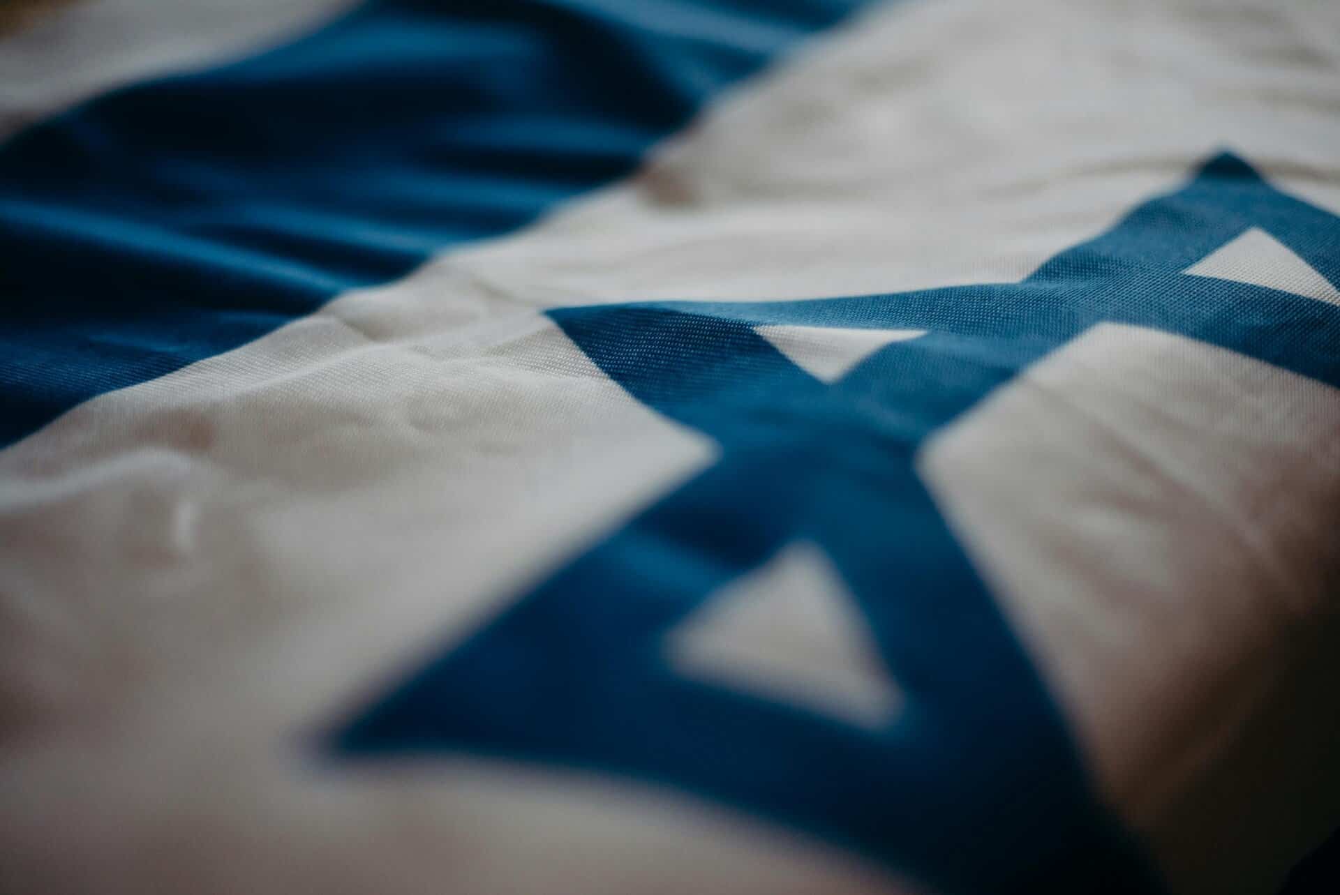 Detail of the Israeli national flag highlighting the Star of David, emphasizing its cultural significance., Warner Bros Discovery