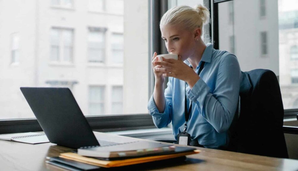 Professional woman enjoying a coffee while working at her office desk, healthier, kombucha, kefir