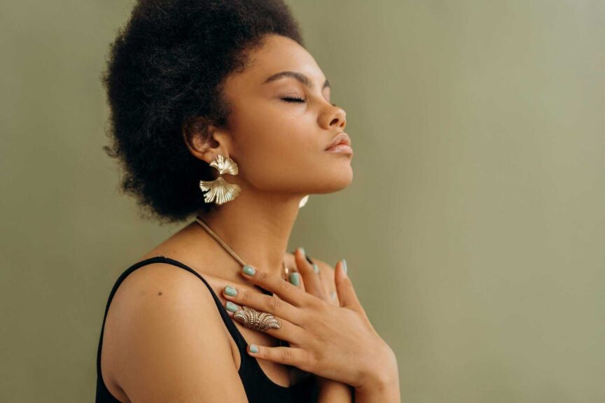 Close-up of a woman with afro hair meditating, eyes closed, embracing wellness and mindfulness, self-awareness