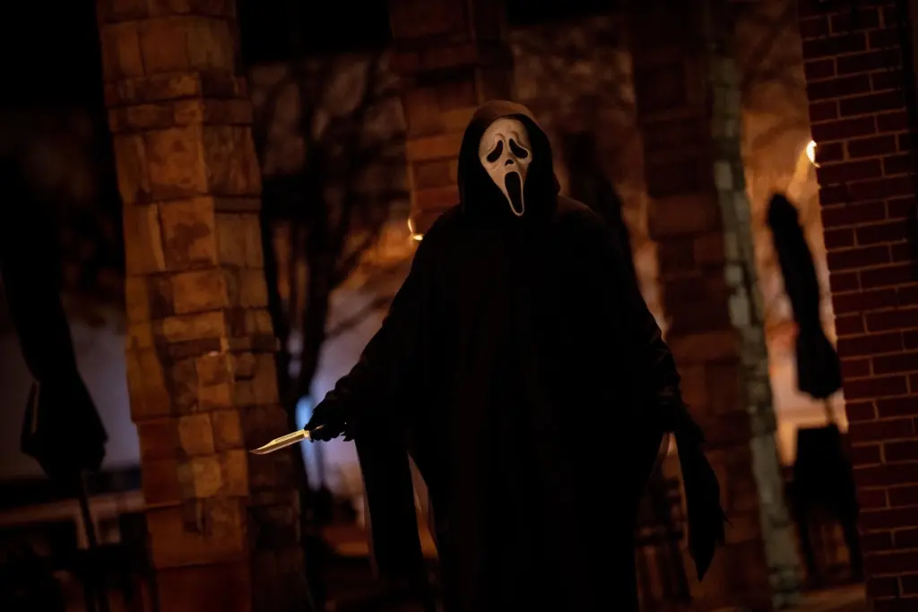 The Ghostface Killer is holding a knife at night.