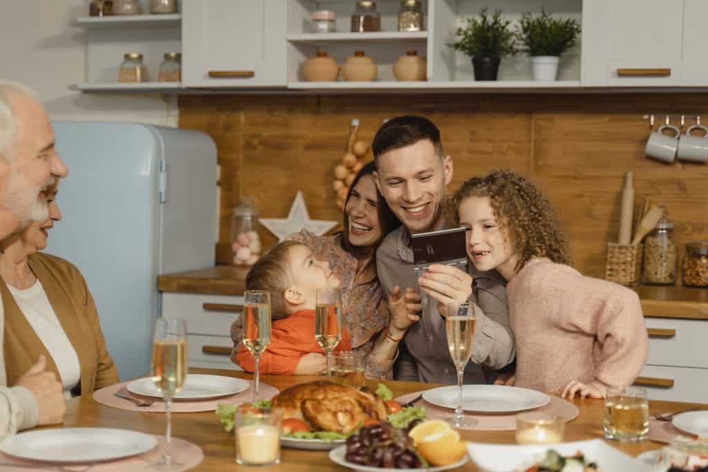This photograph features a family having festive dinner together. The holidays can be a time of productive discussion about ways to co-parent.
