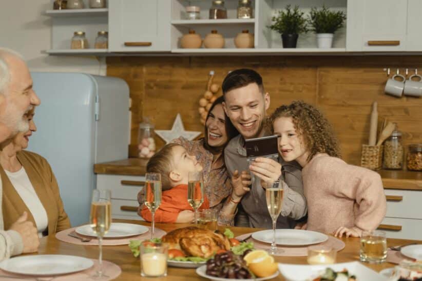 This photograph features a family having festive dinner together. The holidays can be a time of productive discussion about ways to co-parent.