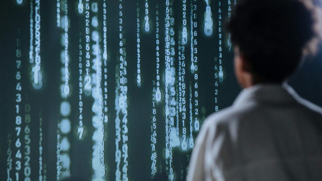 An individual viewing glowing numbers on a screen, symbolizing technology and data. Artificial Intelligence