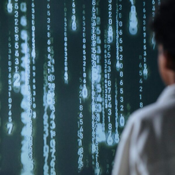 An individual viewing glowing numbers on a screen, symbolizing technology and data. Artificial Intelligence